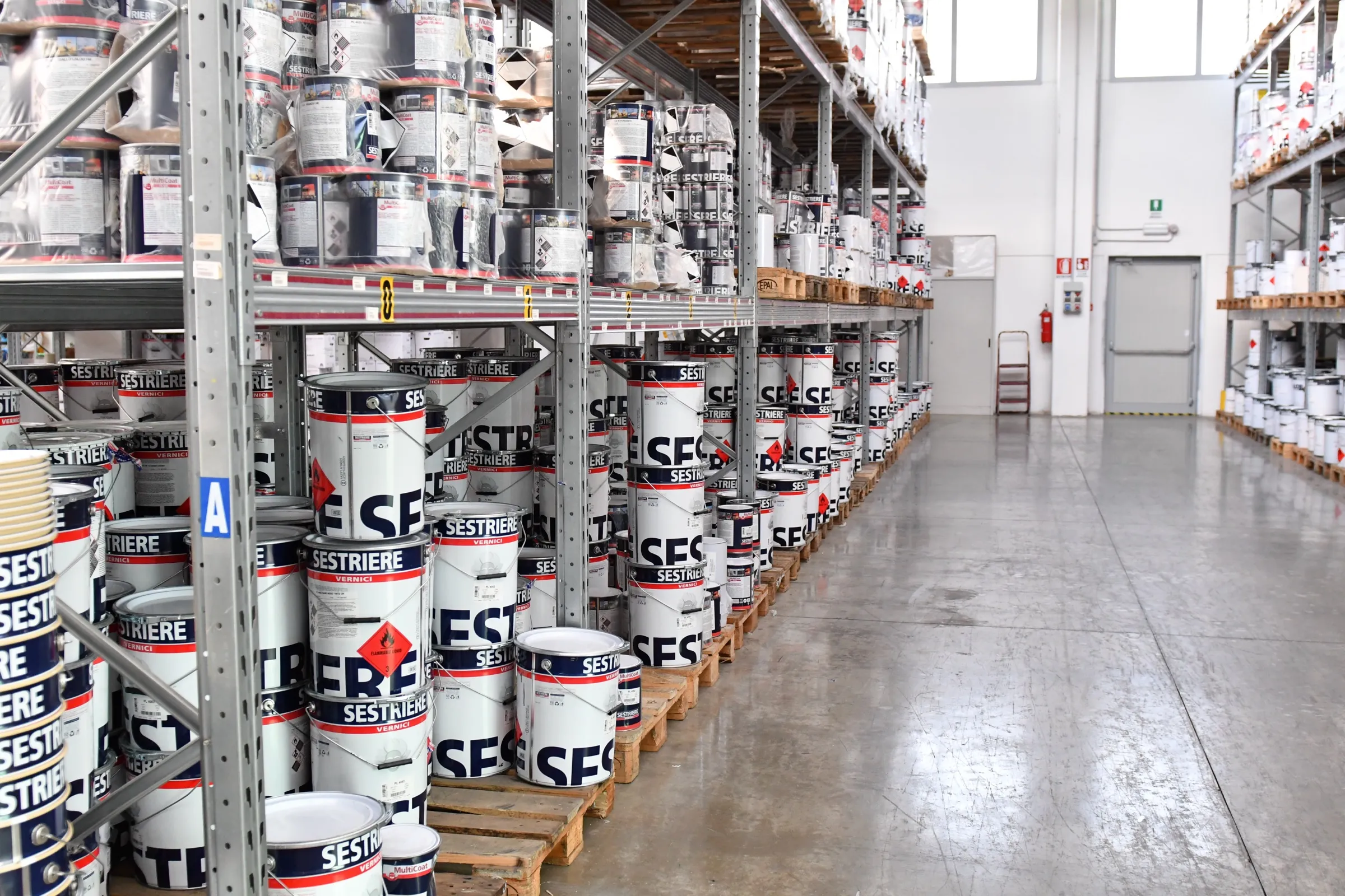 Corsia del magazzino Eleva Coatings con gli scaffali delle vernici