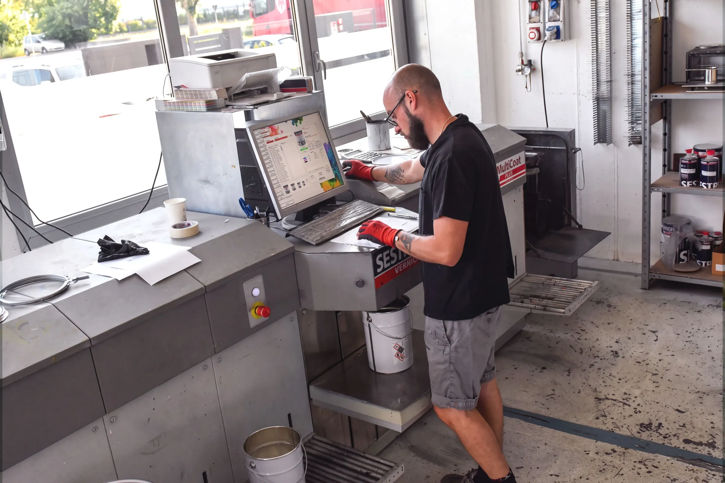 Tecnico Eleva Coatings al tintometro mentre prepara una tinta