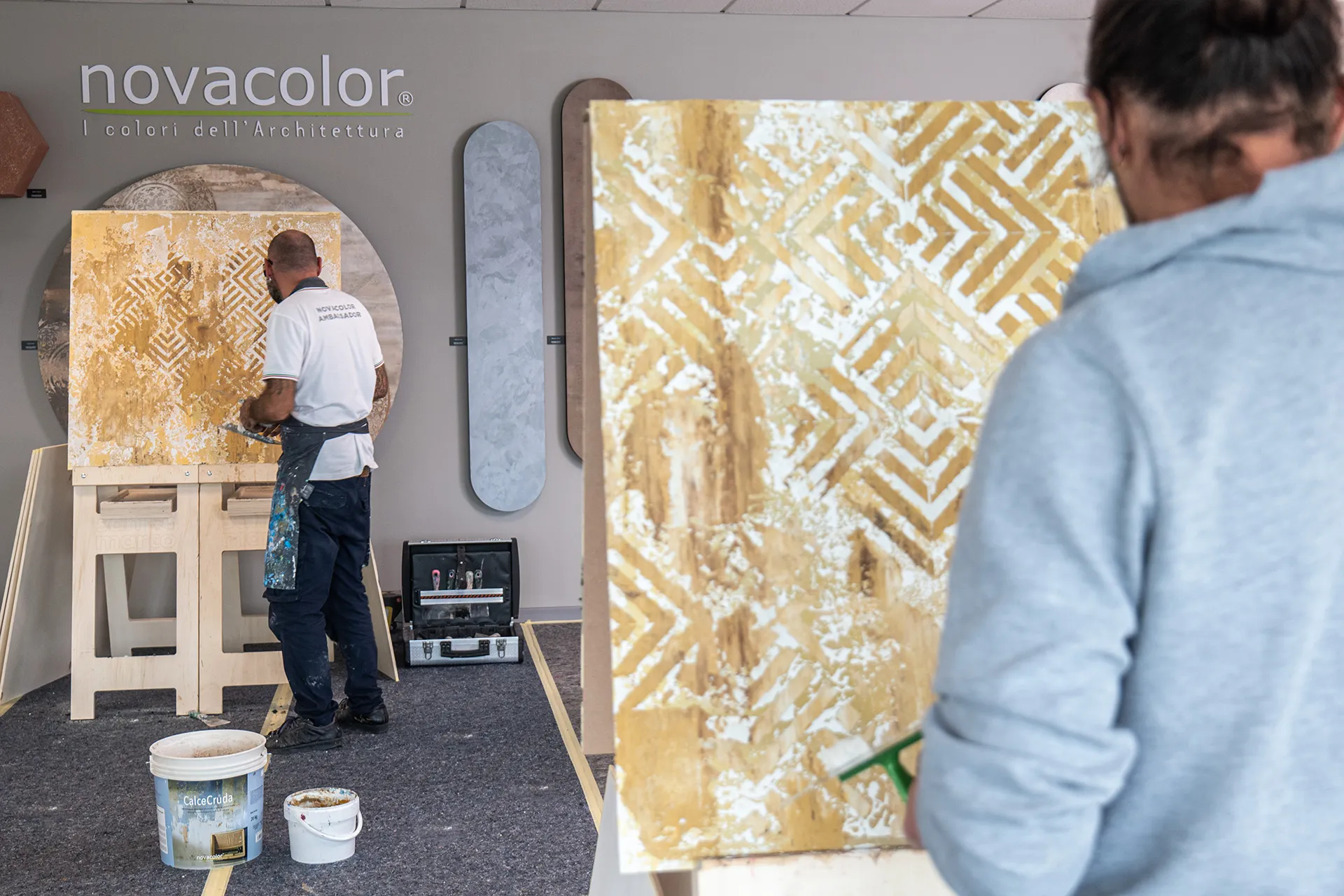 Applicatore Novacolor che realizza una finitura decorativa su un pannello durante una dimostrazione
